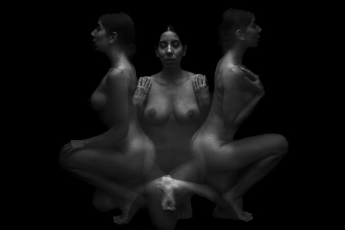 Multiple exposure image of a nude female model in black and white in a lowkey style.